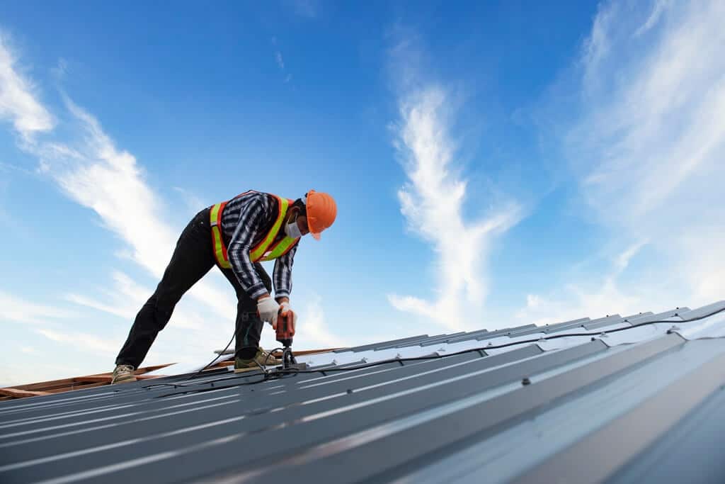 Worker Nailing Metal Roof